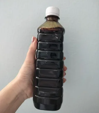 Biomass pyrolysis oil being decanted for quality testing